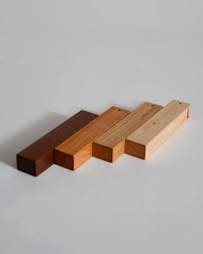 Wooden toothpick cases by Nalata Nalata and Tanno on a gray backdrop